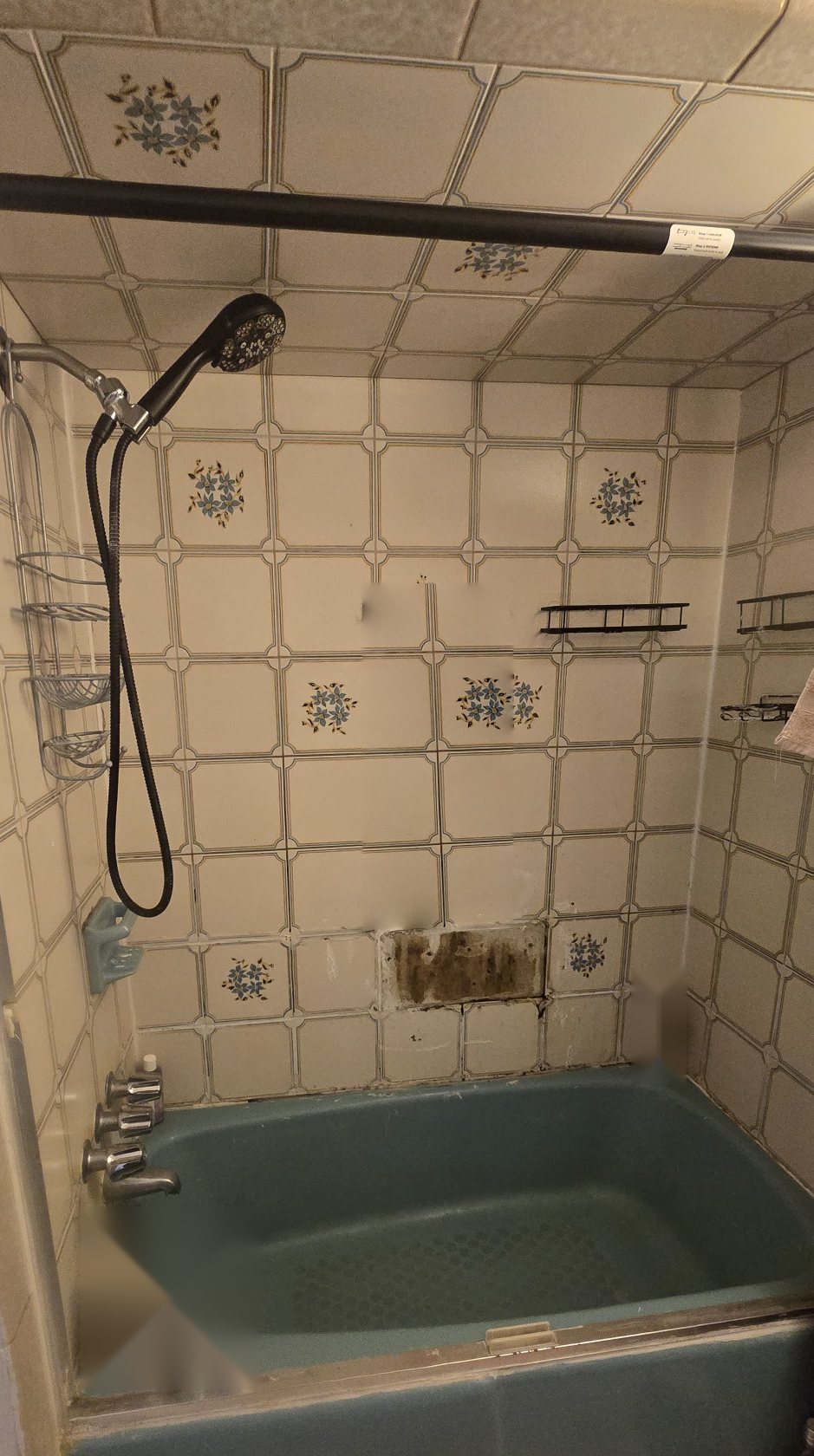 A bathroom before work begins: an older tub and worn tile walls