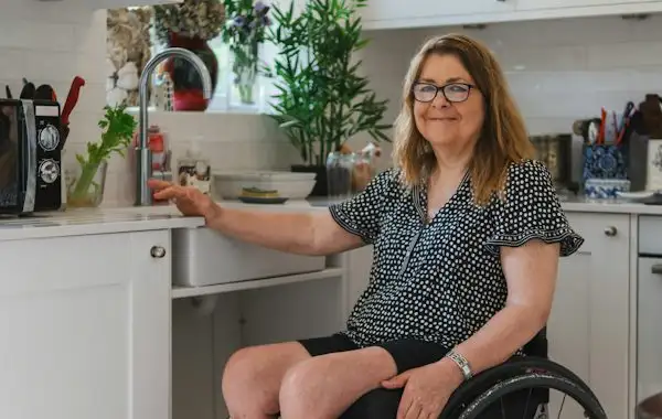 A woman in a wheelchair using her kitchen sink