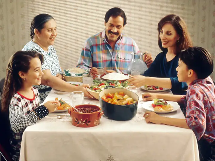 A Latino family sharing dinner around the kitchen table